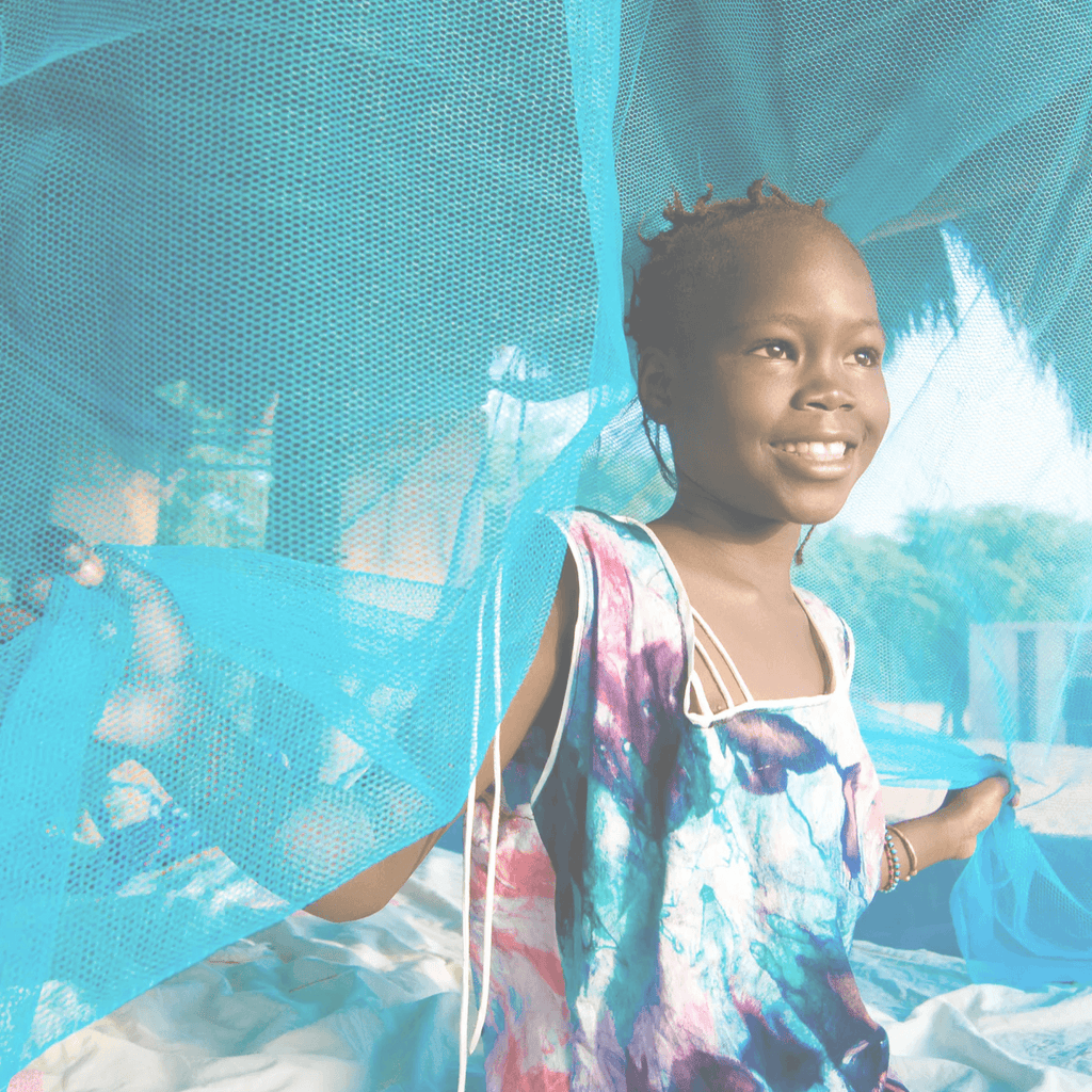 A young African girl smiles because her family received a bed net from efforts funded by Shoo for Good’s partner, Nothing But Nets. She and her family can sleep well without fear of being bitten by malaria-spreading mosquitoes. 